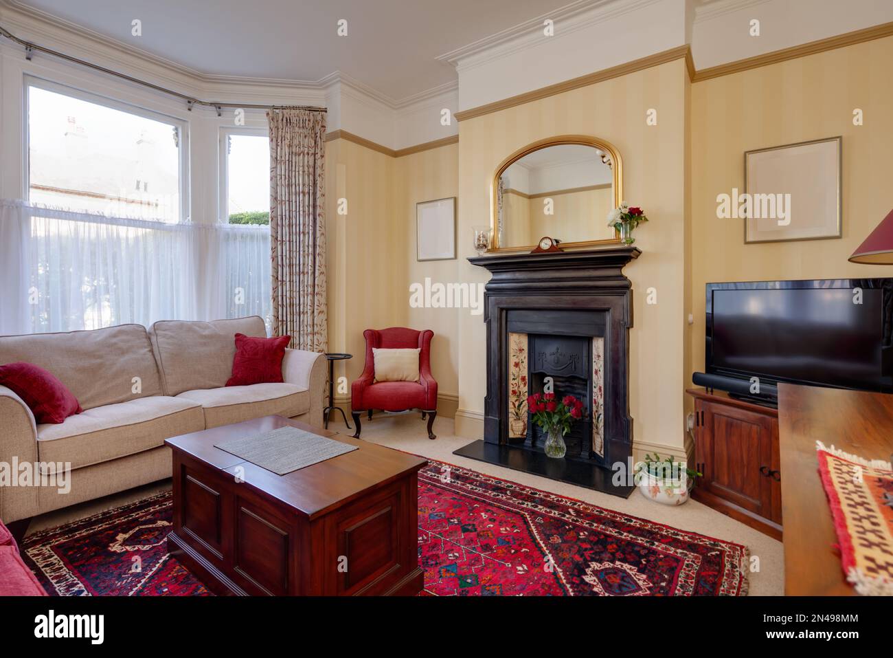 Traditional furnished victorian living room with fireplace. Stock Photo