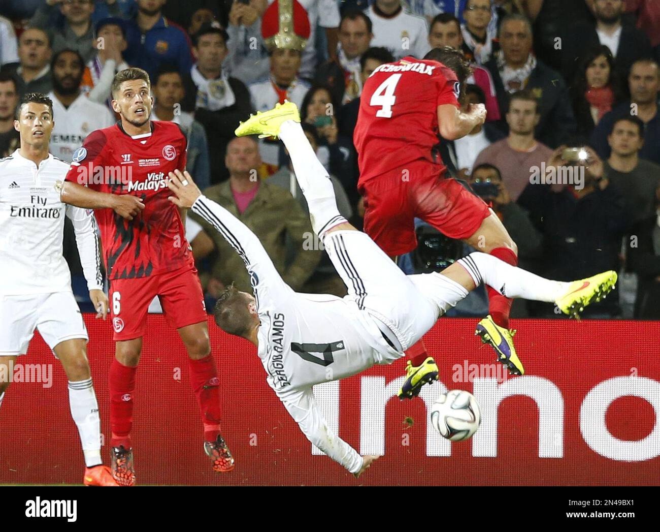 Real Madrid's Sergio Ramos jumps for the ball with Sevilla's