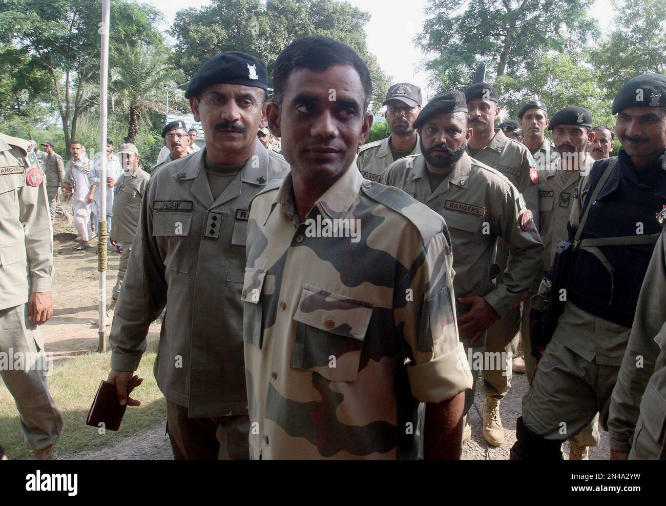 Pakistani troops escort Indian border guard Satyasheel Yadav, center
