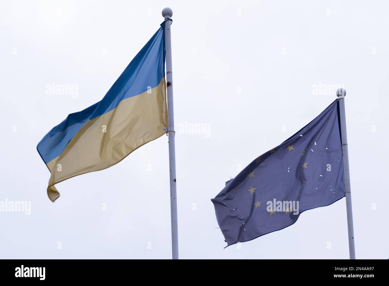 Damaged Ukraine and European Union flags flaying in Irpin, Ukraine in February 2023 Stock Photo