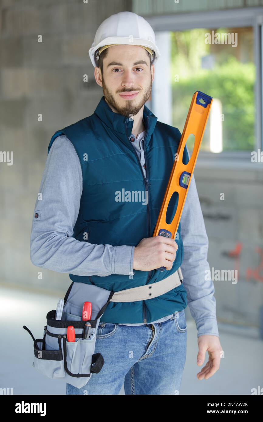 builder is holding spirit level Stock Photo - Alamy