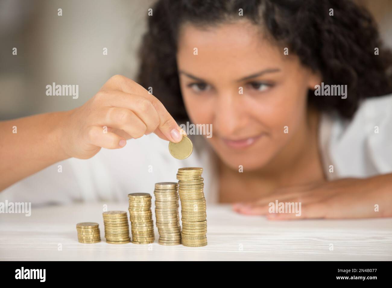 woman with stacks of coins Stock Photo