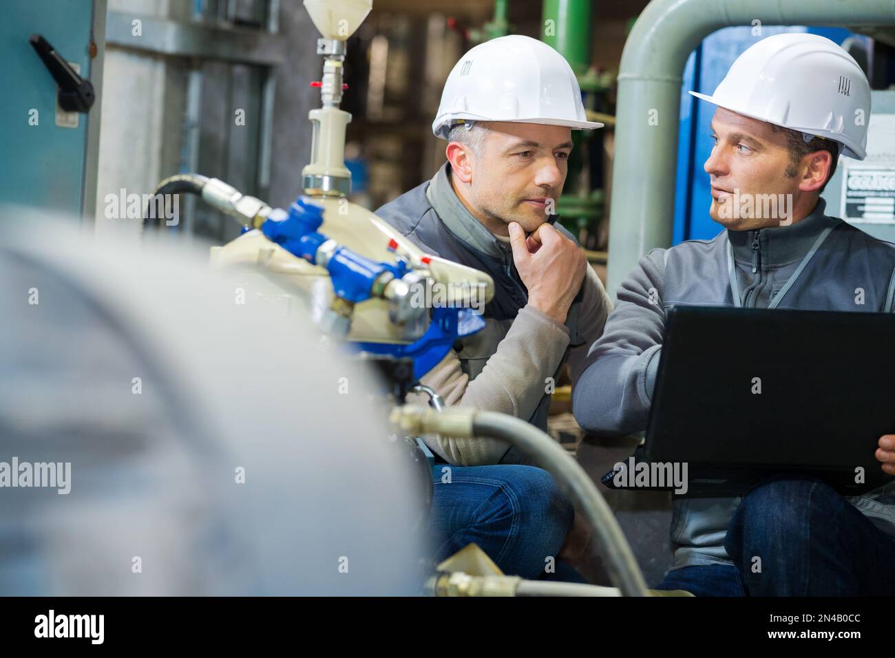 men with laptop presenting business project in factory Stock Photo