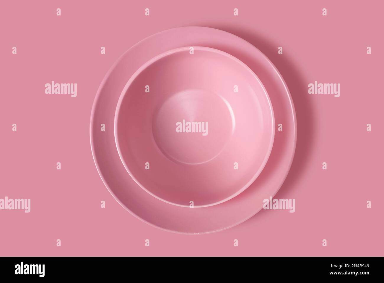 Two pink plates on a pink background. View from above. Concept Stock ...