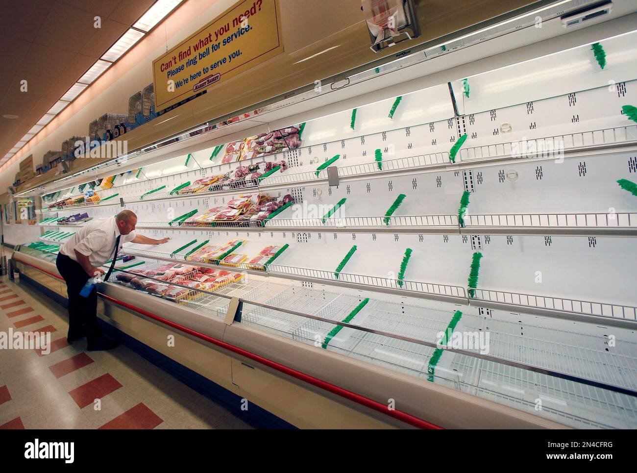 Meat manager Dave Fillebrown wipes down largely empty shelves Thursday, July 24, 2014 at a