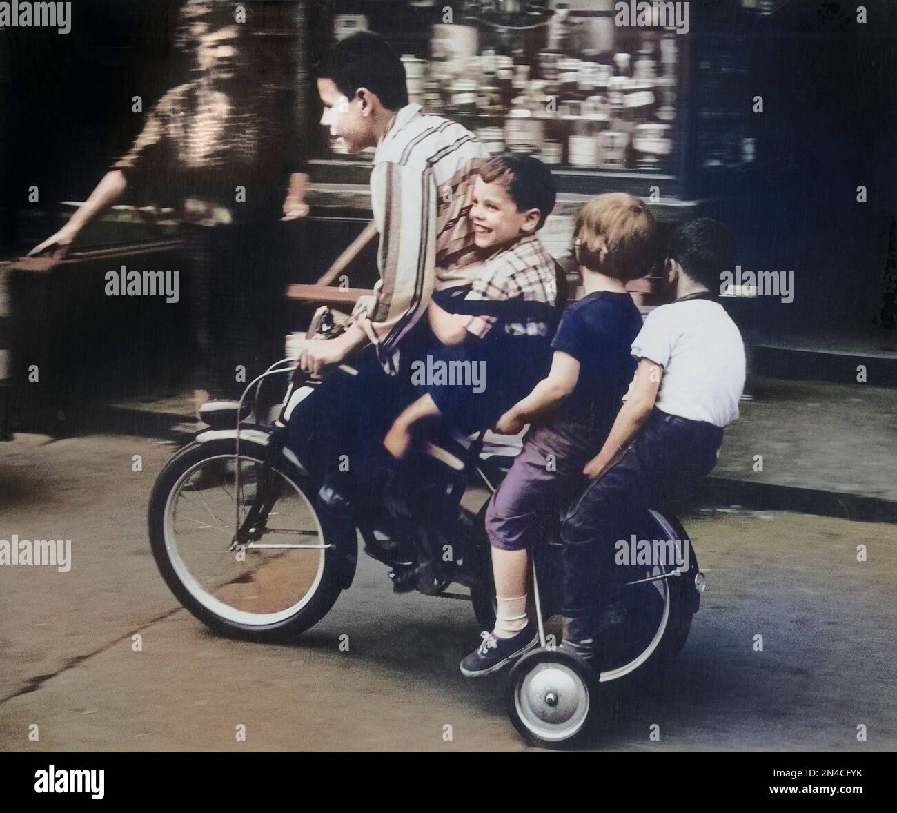 Four Children riding Bicycle on Sidewalk, New York City, New York, USA, Angelo Rizzuto, Anthony Angel Collection, June 1958 Stock Photo