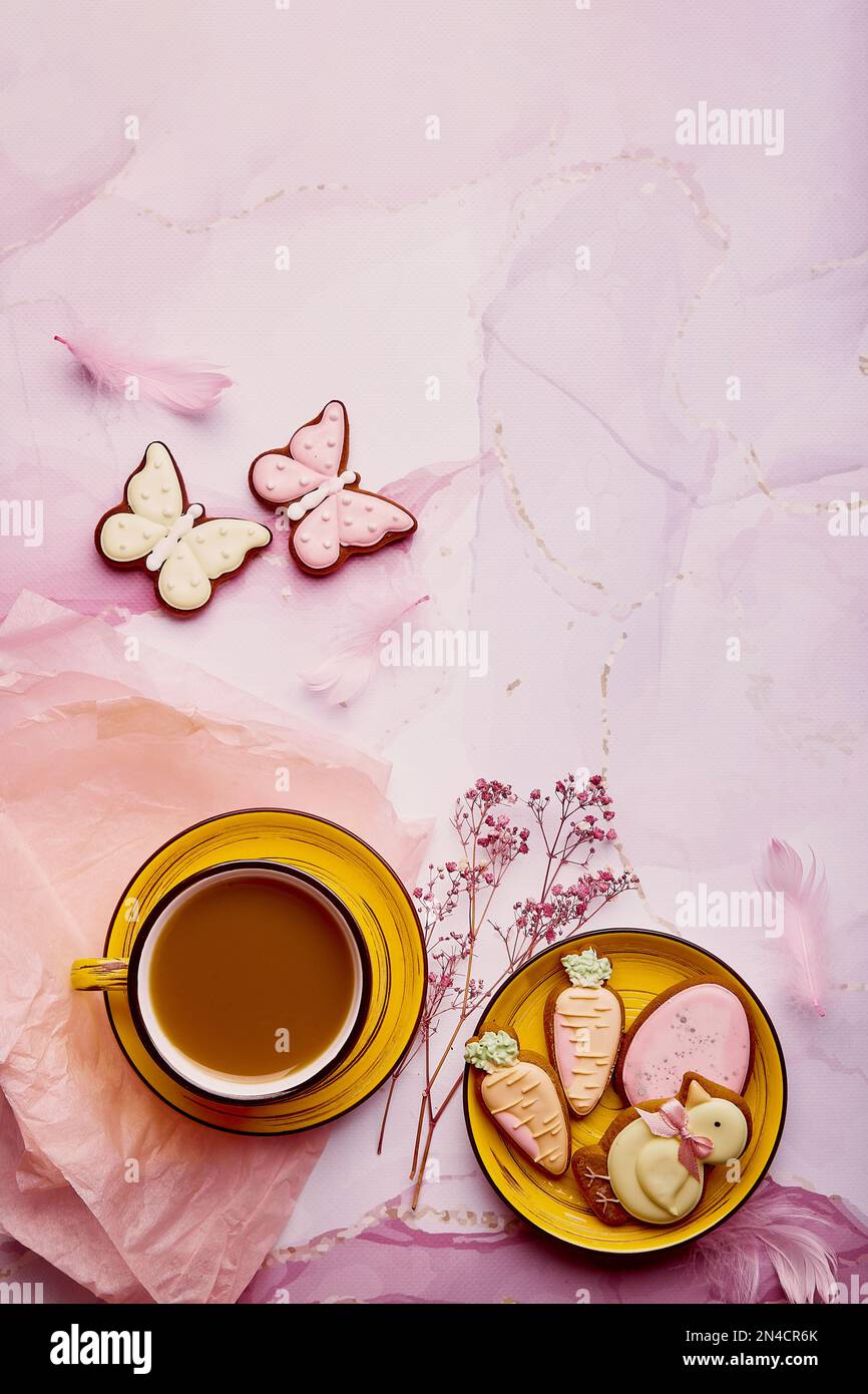 Pastel Easter background - glazed cookies with coffee. Spring aesthetics card with baked symbols of Easter, copy space. Stock Photo