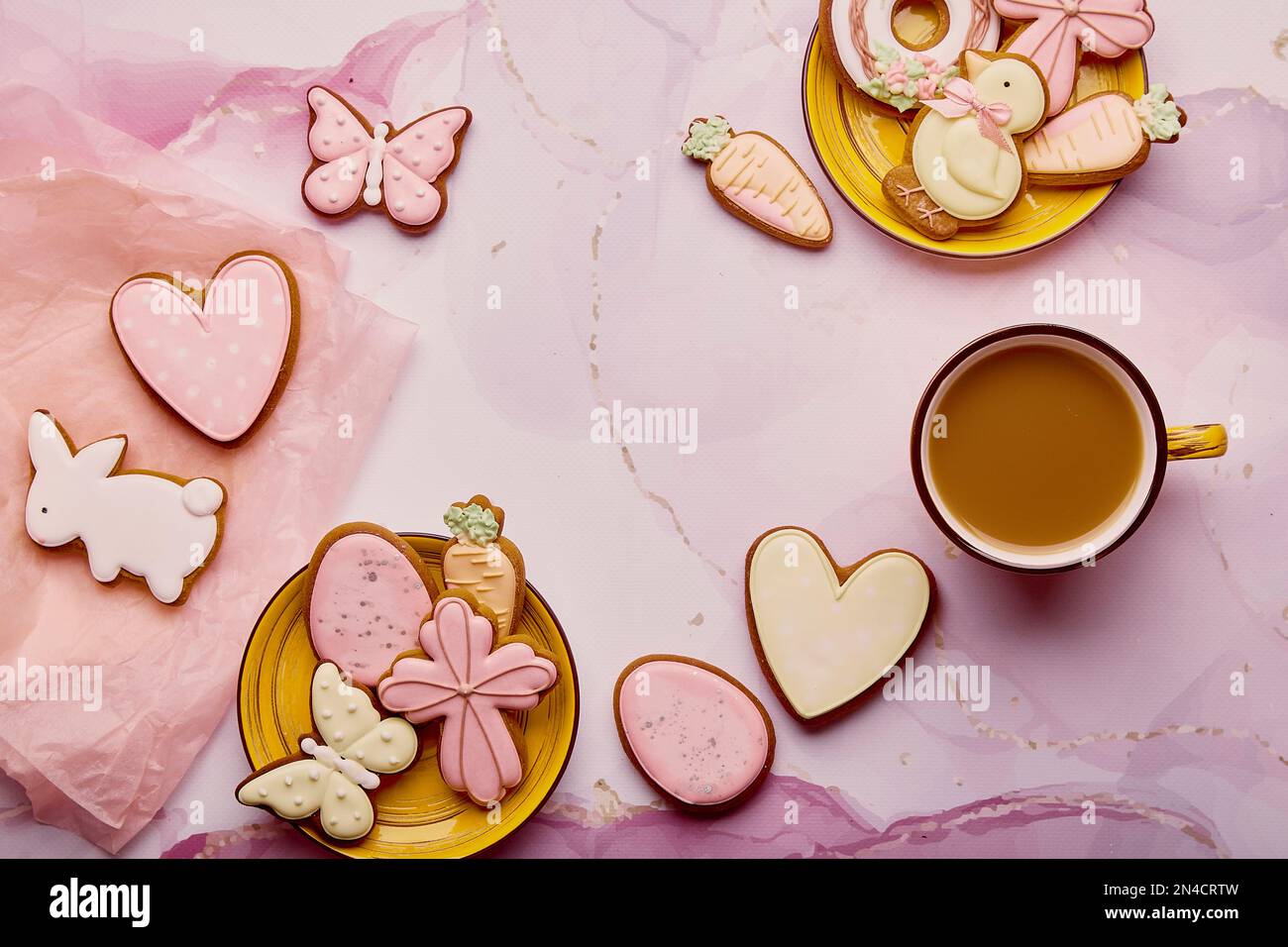 Aesthetics Easter background - pastel cookies and coffee, copy space. Spring card with baked glazed symbols of Easter on pink background Stock Photo