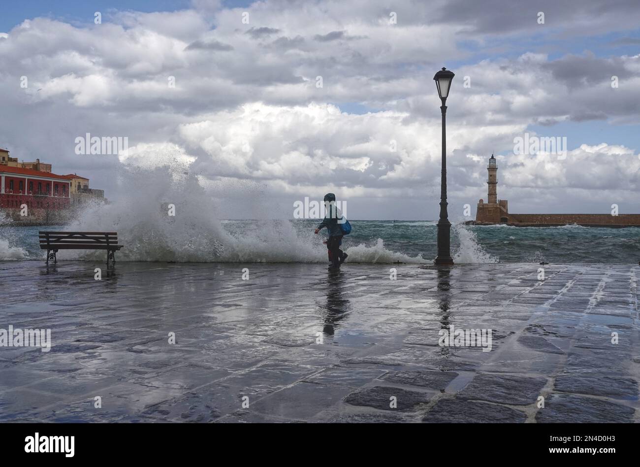 Wet, stormy weather and crashing waves at the quayside in the Venetian harbour of Chania old town in Crete, Greece Stock Photo