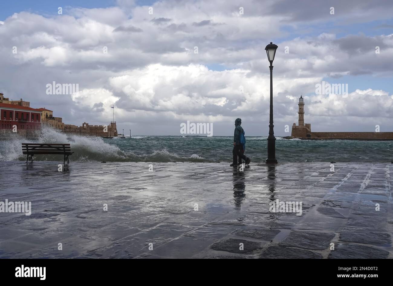 Wet, stormy weather and crashing waves at the quayside in the Venetian harbour of Chania old town in Crete, Greece Stock Photo