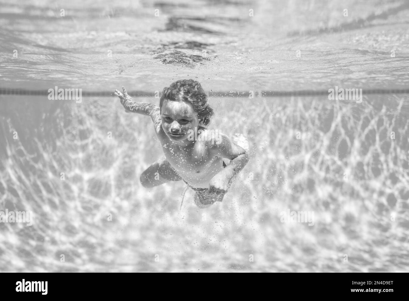 Underwater kids swims in pool, healthy child swimming and having fun