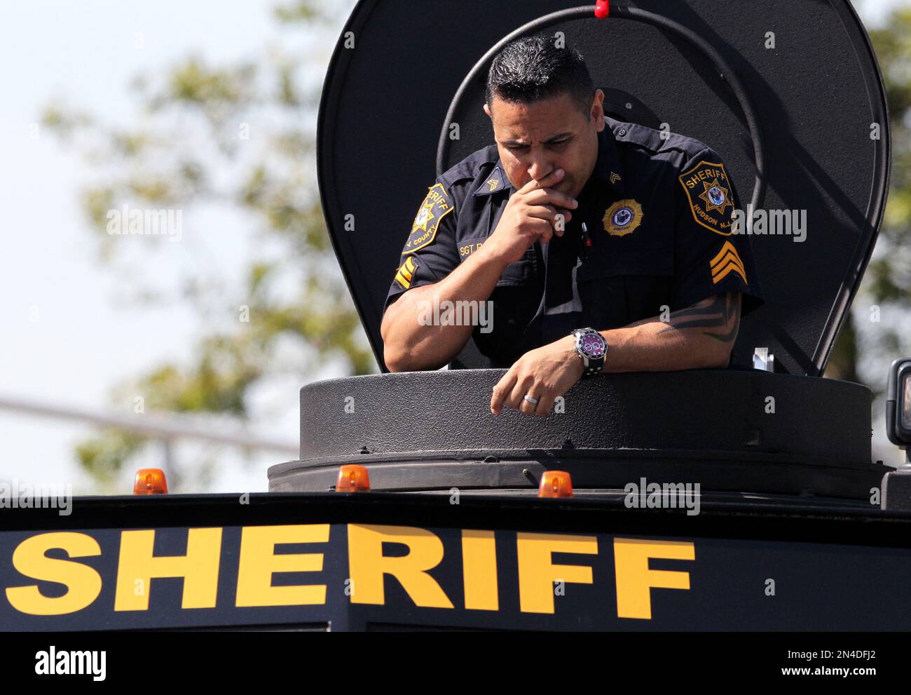A Hudson County Sheriff's officer stands on the gunner perch of an