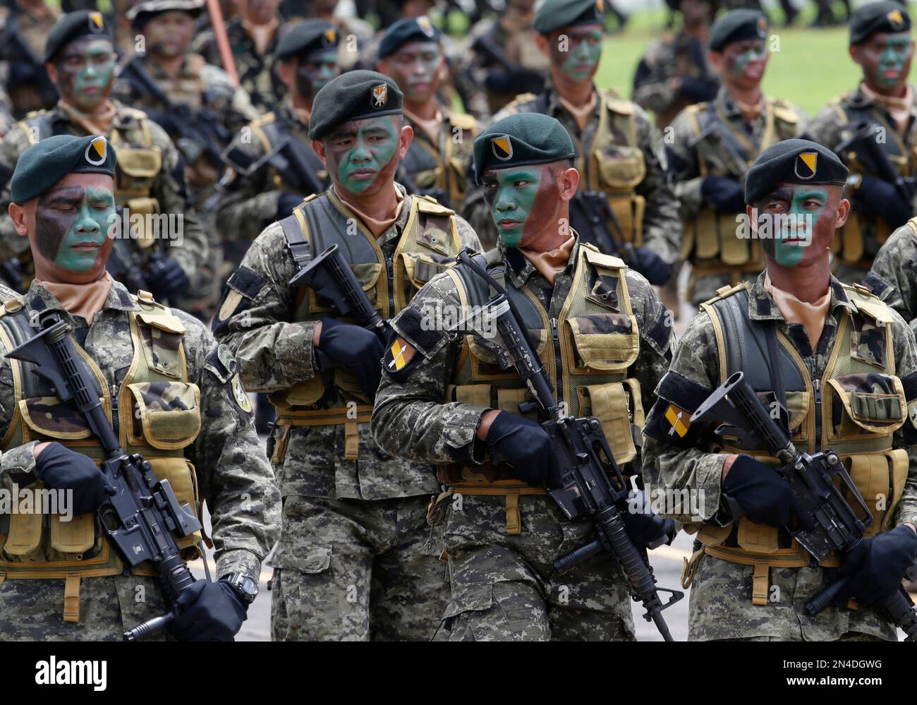 Philippine troops march past the grandstand to welcome the new ...