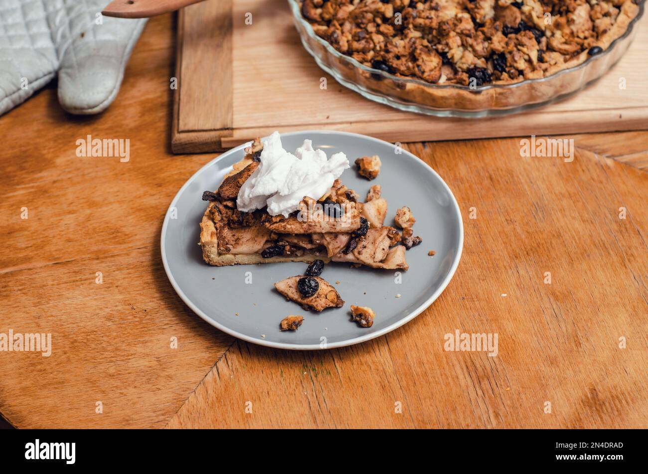 A piece of sweet cake with nuts, apples on a blue plate Stock Photo