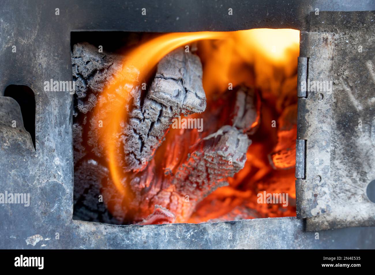 Fire burning in small black iron stove. Closeup photo with selective