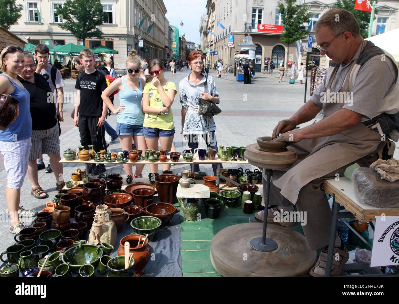 Cracow. Krakow.Poland. Tourists watching potter throwing a pot on potters wheel . Folk art fair annual festival. Stock Photo