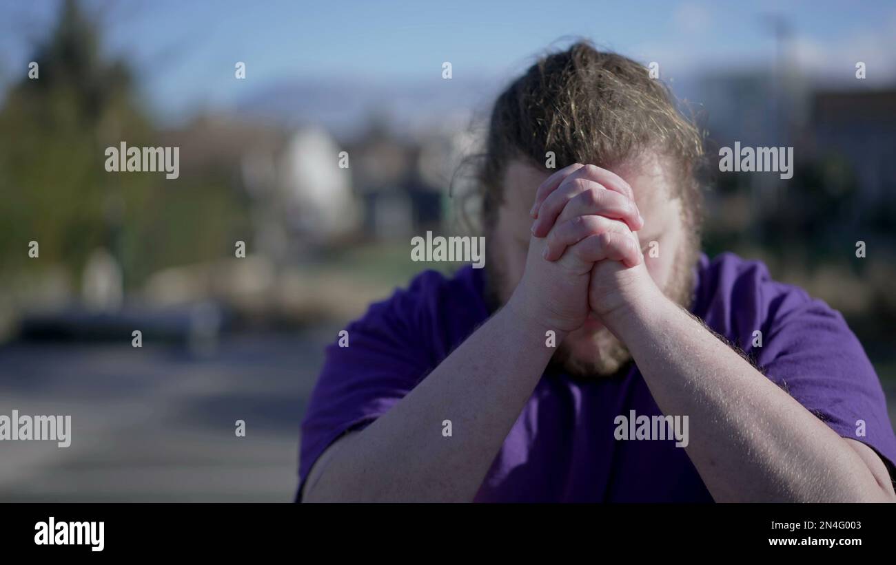 One Spiritual young man raising arms in the air asking for God help