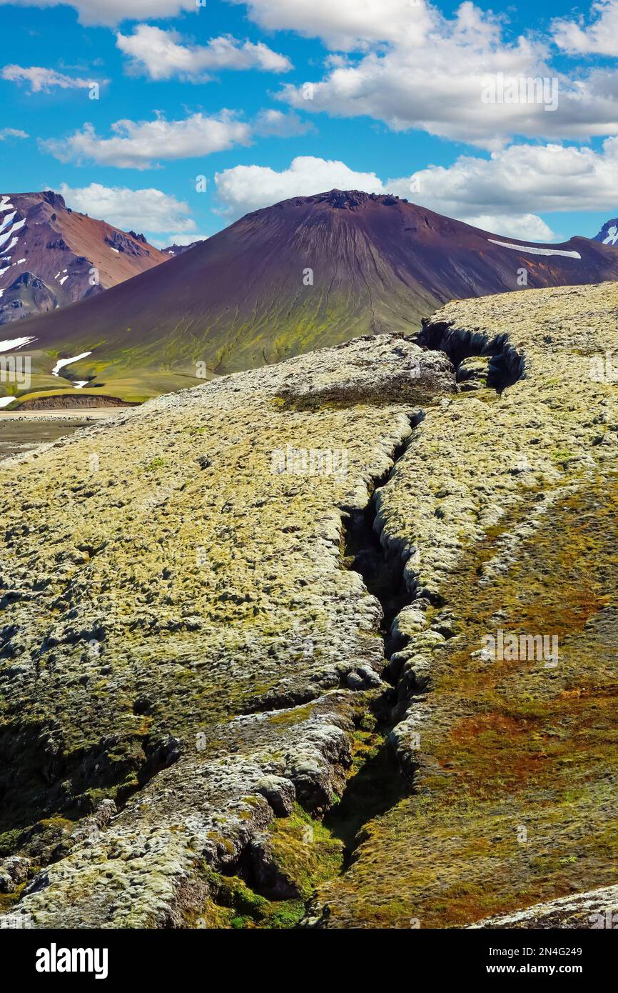 Fissure of the ground leading to cone of black volcano crater cone - Grabrok Grabrokarfell Iceland Stock Photo