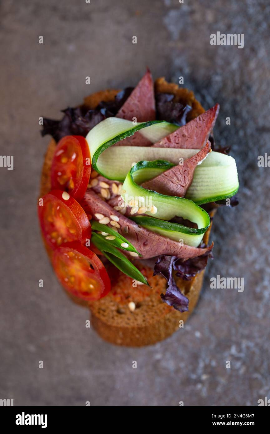 bruschetta with meat, tomato and fresh cucumber closeup Stock Photo
