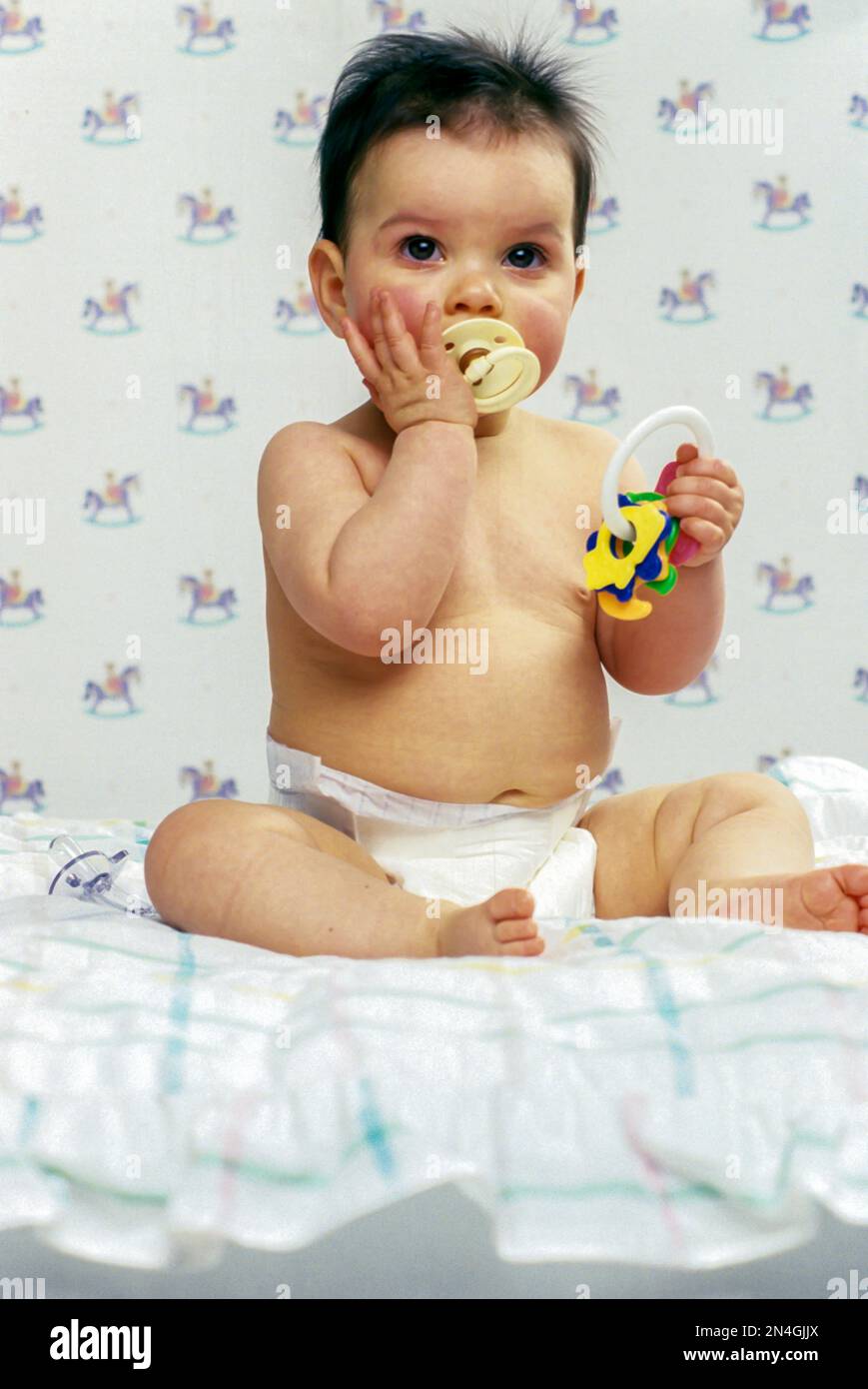 CRYING CAUCASIAN INFANT BABY PLAYING WITH COLORED PLASTIC TOY KEYS Stock Photo
