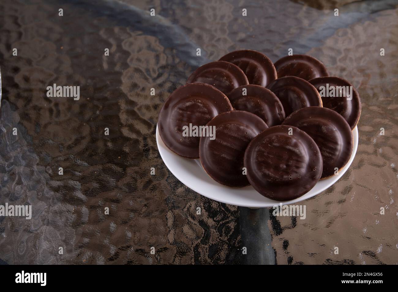 photo of a plate of chocolate chip cookies on a glass table Stock Photo