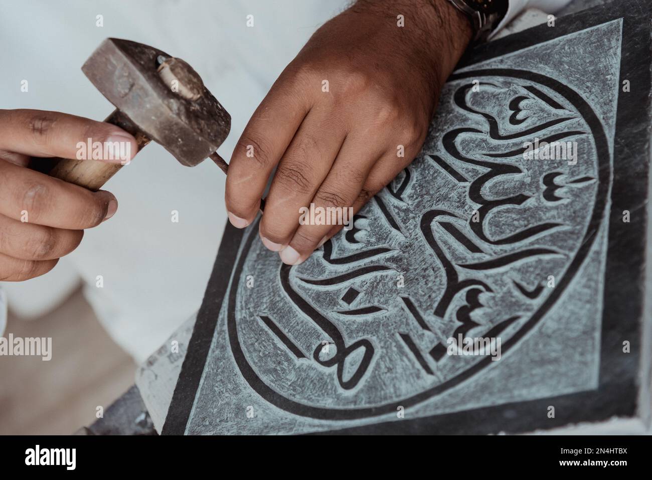 Crafting an Islamic verse on a marble slate by an artist in Pakistan Stock Photo