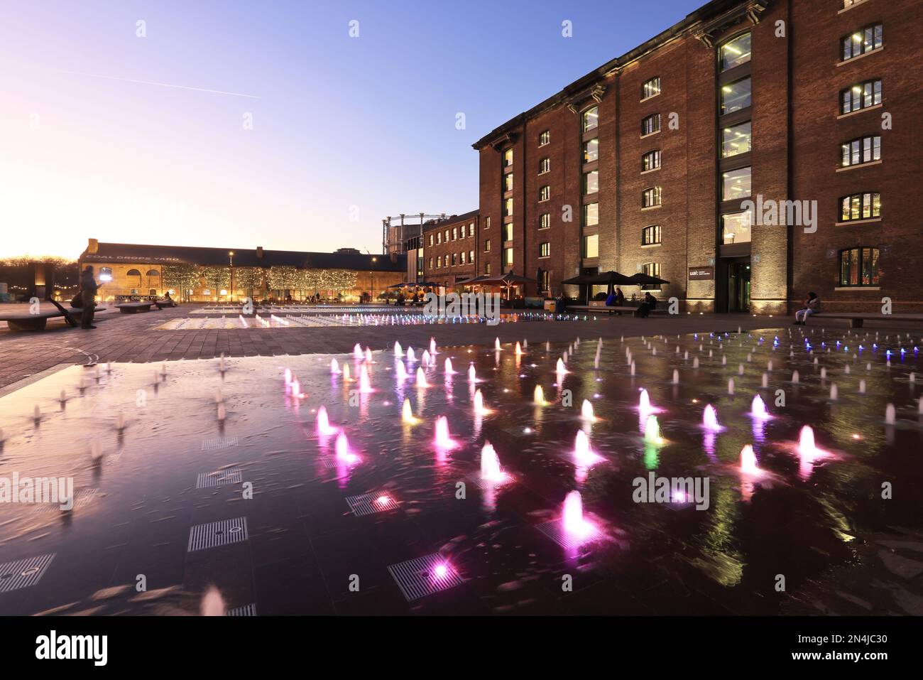 Coloured fountains in Granary Square at dusk in winter weather, at