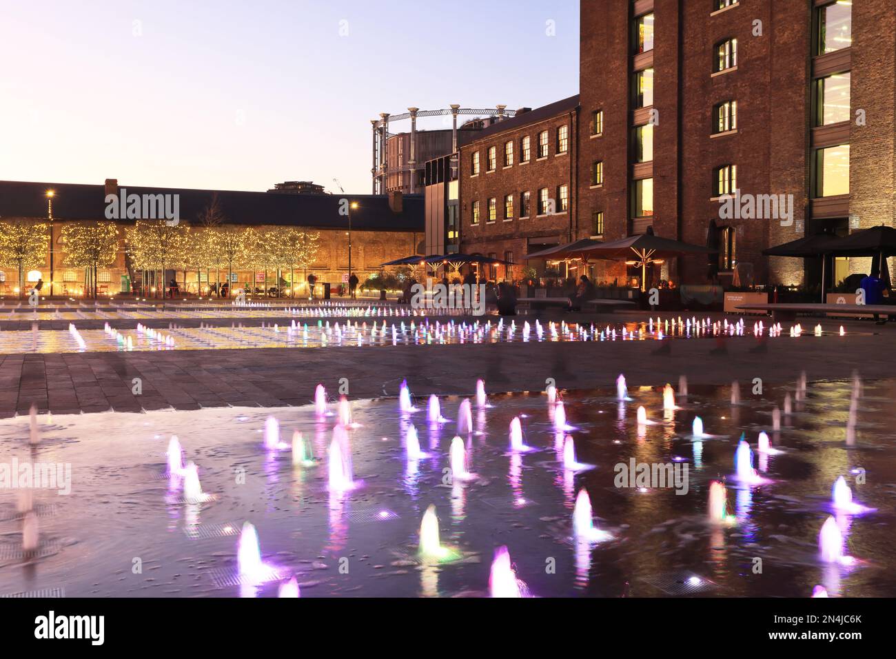 Coloured fountains in Granary Square at dusk in winter weather, at