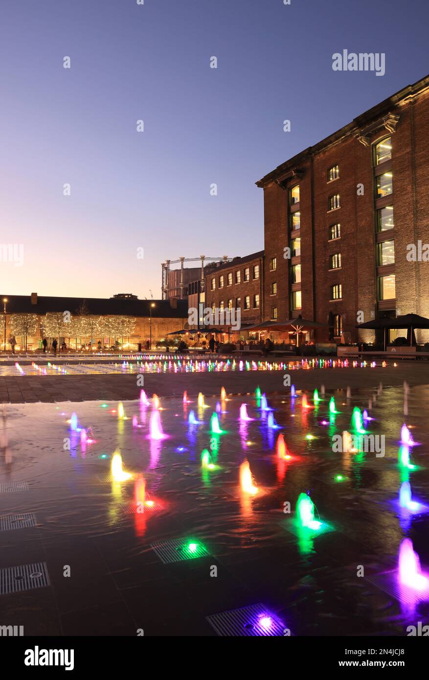 Coloured fountains in Granary Square at dusk in winter weather, at