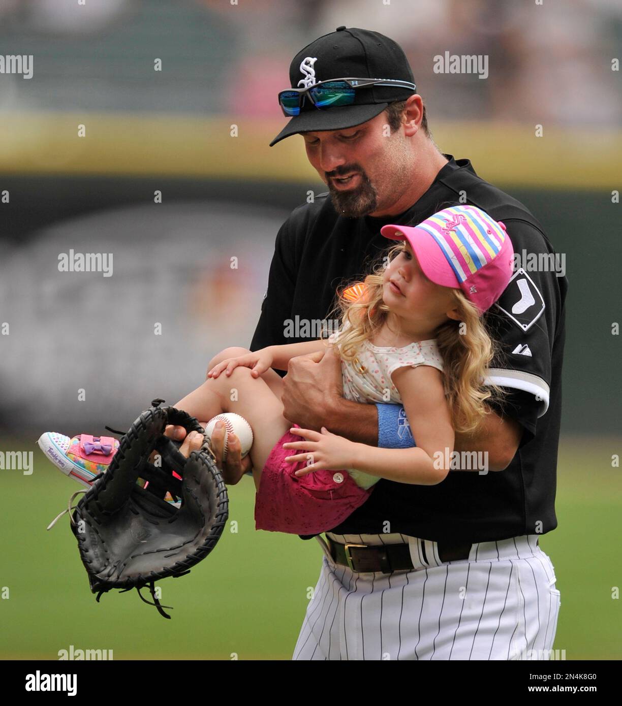 Amelia Konerko, 2, is carried off the field by her father, Chicago White  Sox player Paul Konerko, after she threw out a ceremonial first pitch  before a baseball game between the White