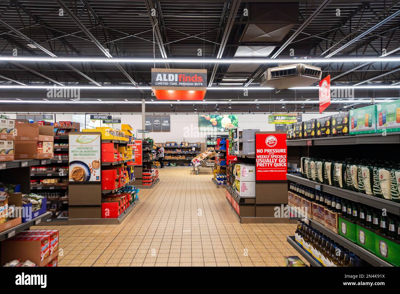 Inside of Aldi's grocery store with a female shopper in the distance. USA. Stock Photo