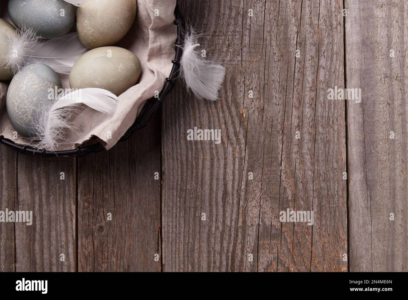 Eggs and feathers on rustic wooden table. Easter celebration concept Stock Photo
