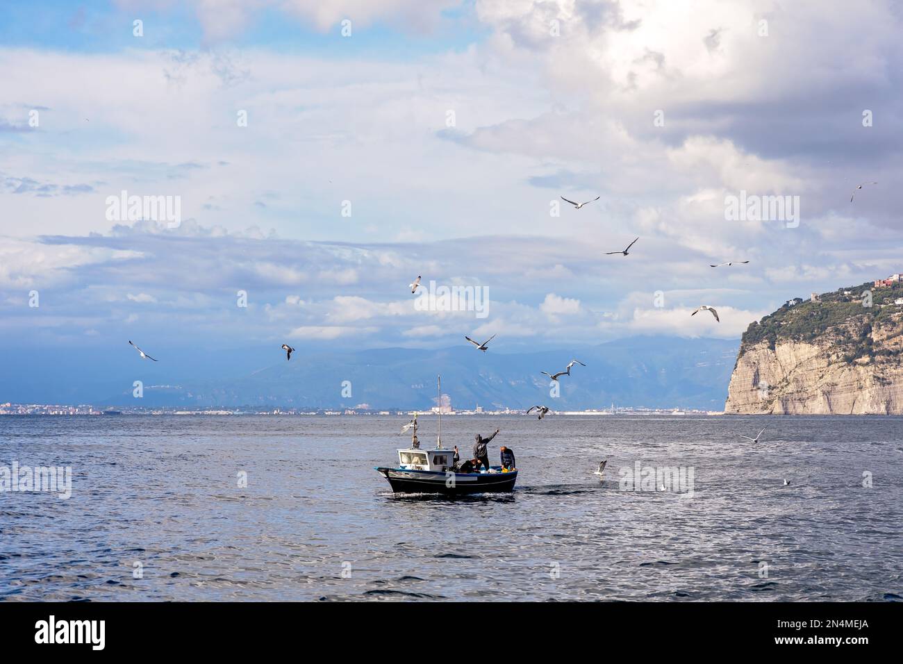 Sorrento, Italy - Fisherman on his boat getting fresh seafood in Naples Bay. Food is then cooked and served in a local restaurant in Sorrento, Marina . Stock Photo