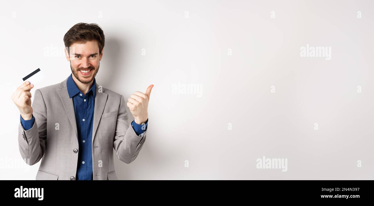 Happy bank client in business suit showing plastic credit card and ...