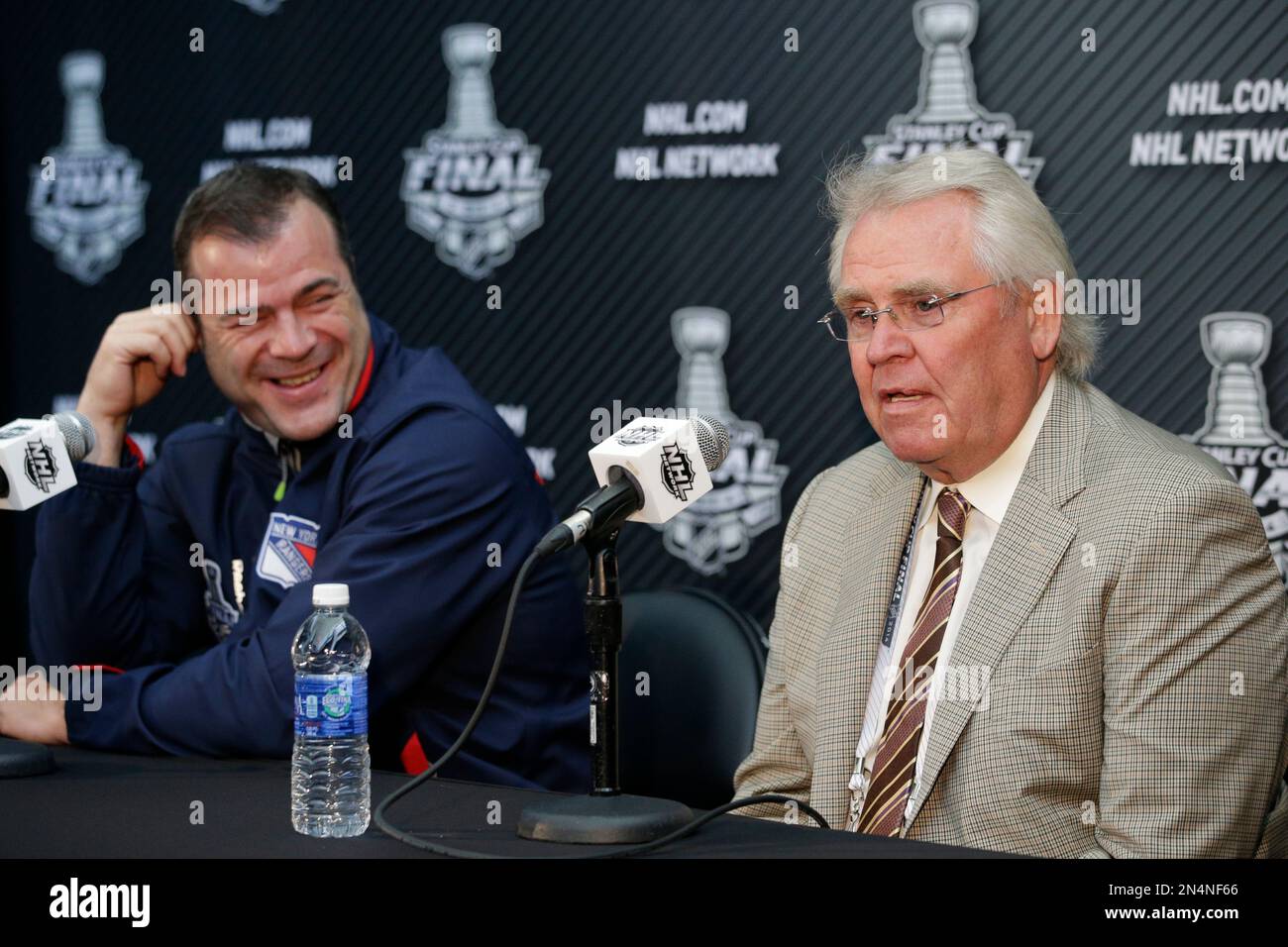 New York Rangers head coach Alain Vigneault, left, smiles while