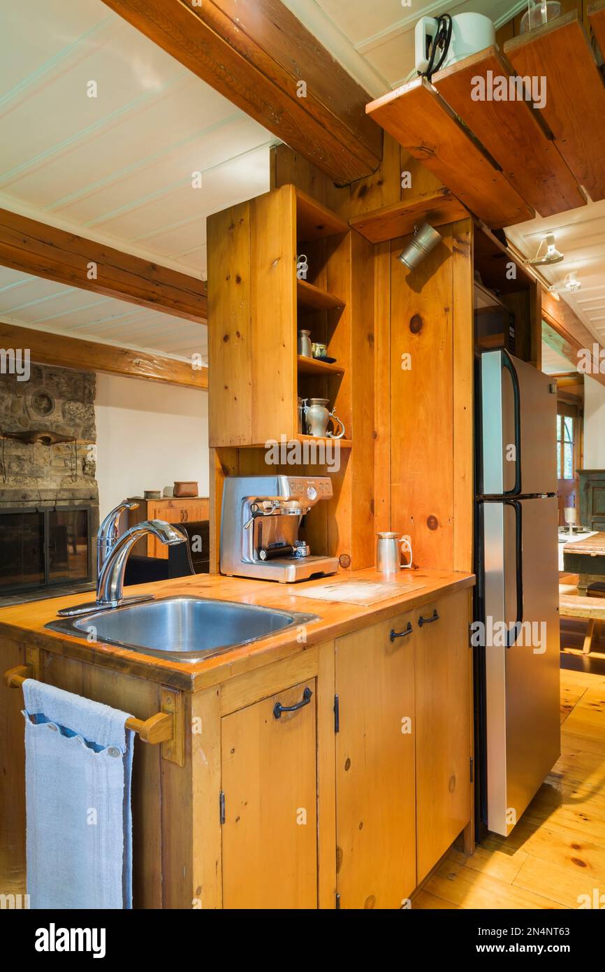 Small rustic kitchen with pine wood countertop, sink and