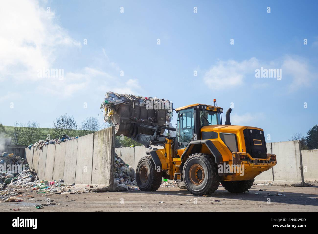 Front loader with scrap handling grapple bucket moving forward and