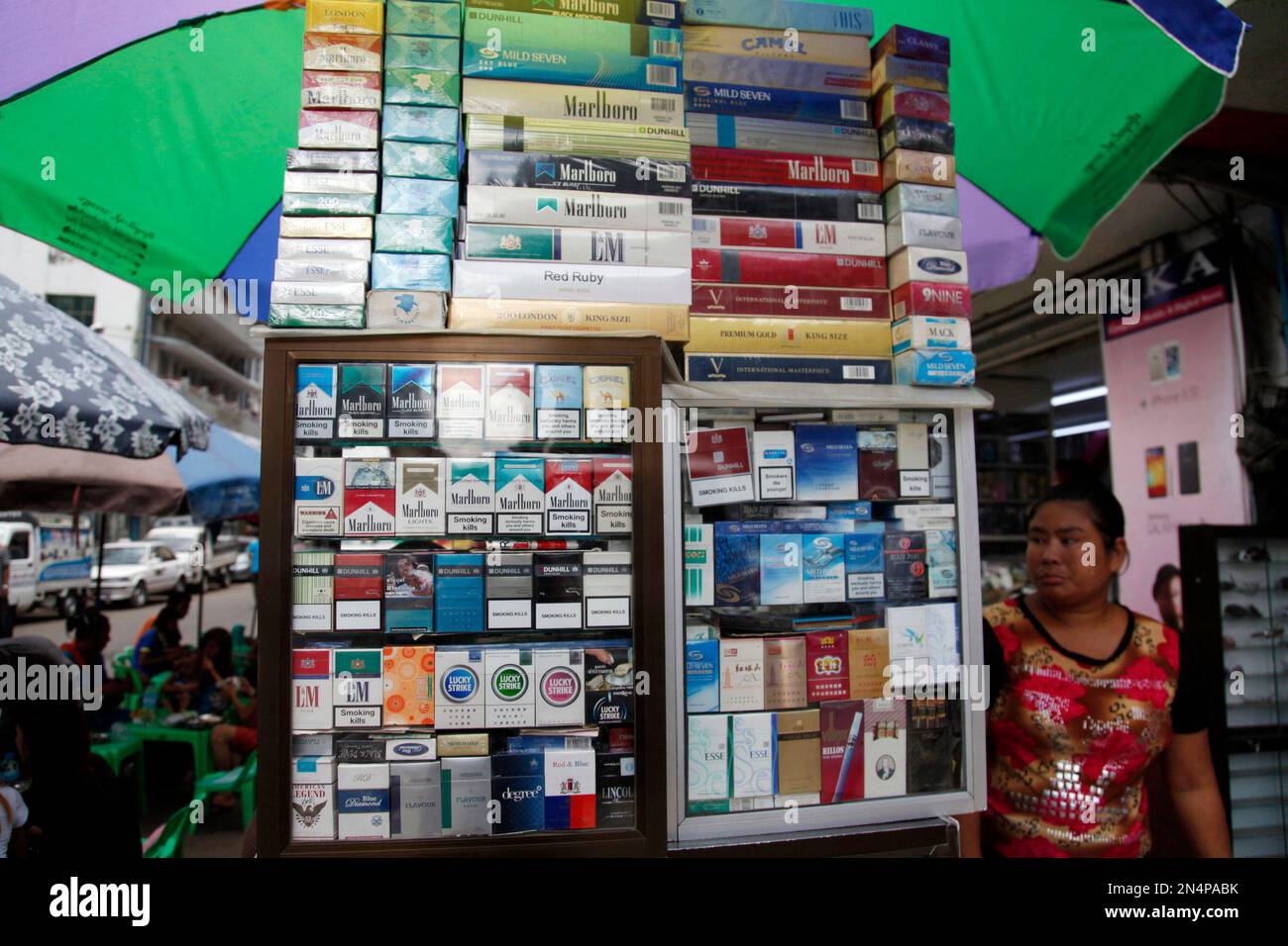 A vendor waits for customers as various kind of cigarette are displayed in  a showcase on World No Tobacco Day Saturday, May 31, 2014, in Yangon,  Myanmar. (AP Photo/Khin Maung Win Stock