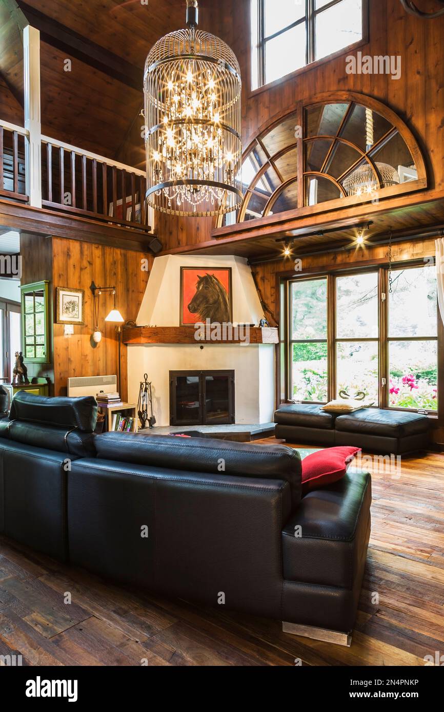 Living room with black leather sofas, glass top coffee table and ...