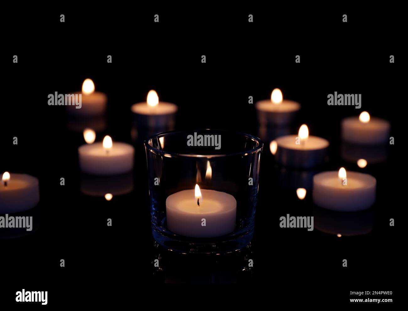 Beautiful burning wax candles on black background Stock Photo - Alamy