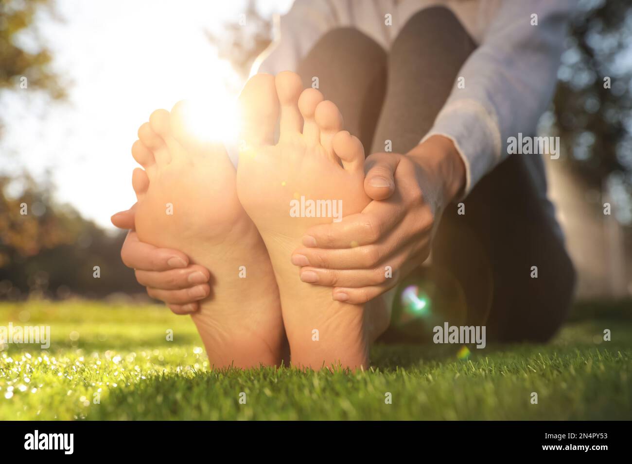 Woman sitting on grass barefoot hi-res stock photography and images - Alamy