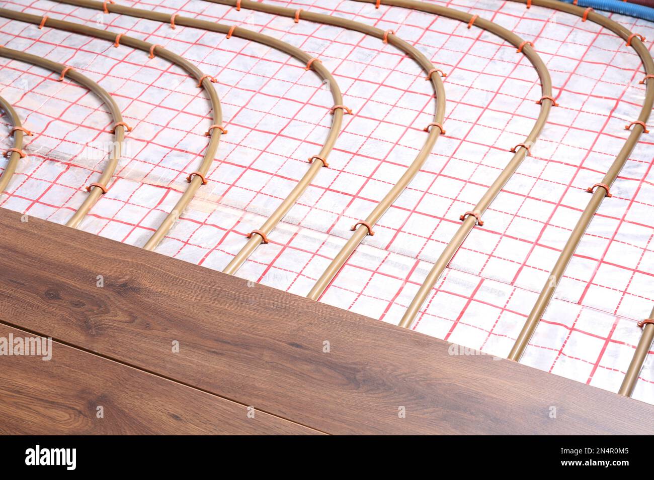 Installing new wooden laminate over underfloor heating system Stock