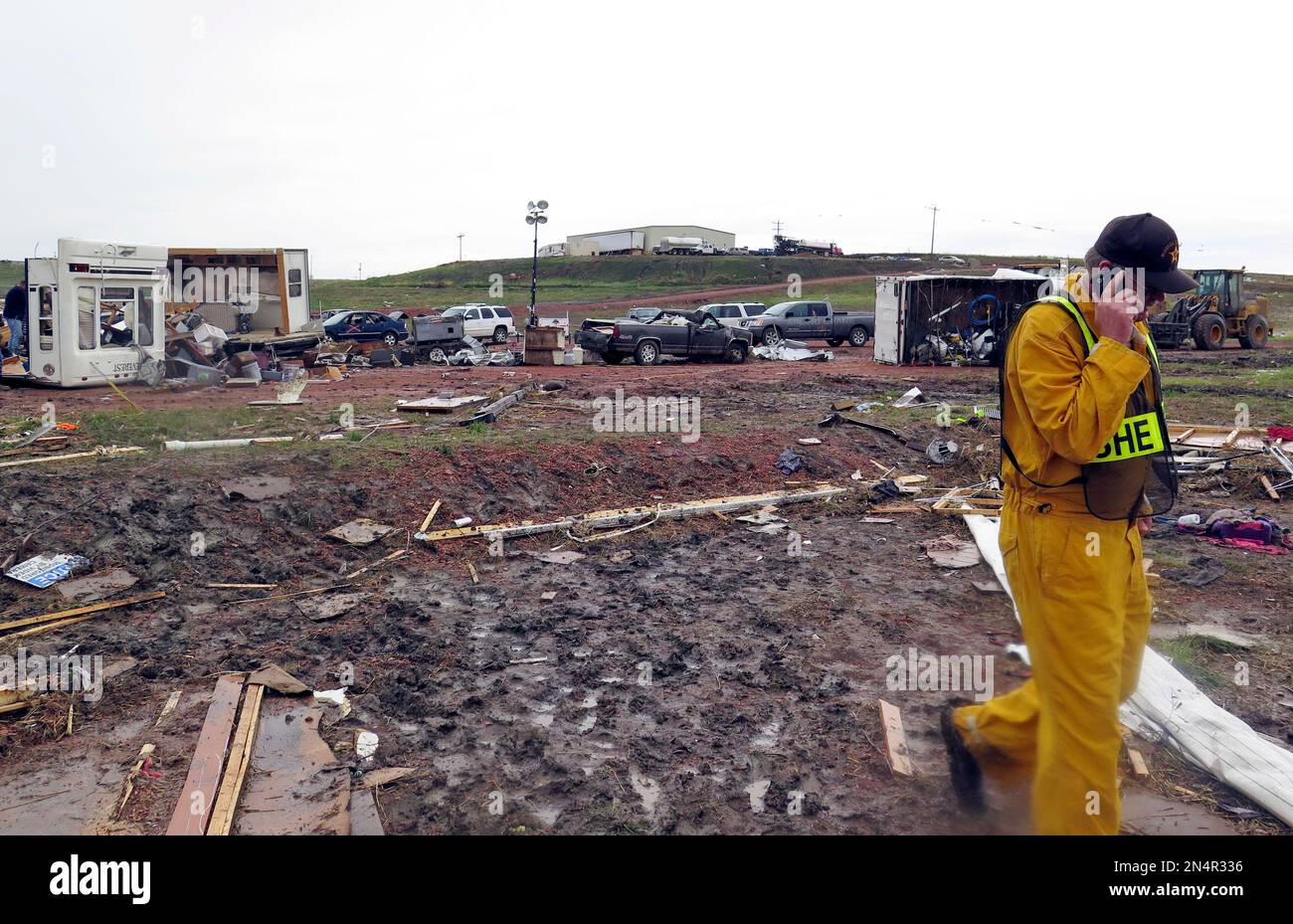 A McKenzie County Sheriff talks on a phone among scatterd debris