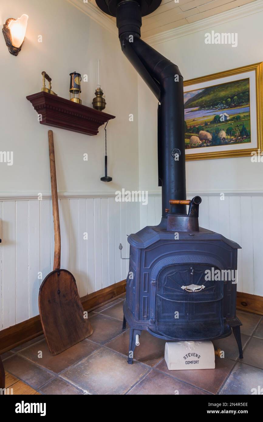 Black cast iron 1977 Vernon Casting wood burning stove in living room inside old 1892 home. Stock Photo