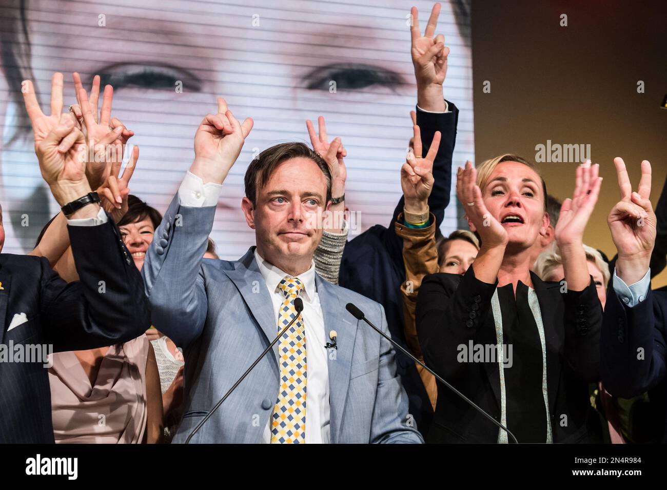 The leader of the NVA (New Flemish Alliance) Bart De Wever, left, makes a  victory sign as he addresses his party members after winning the Belgian  federal and regional elections, in Brussels,