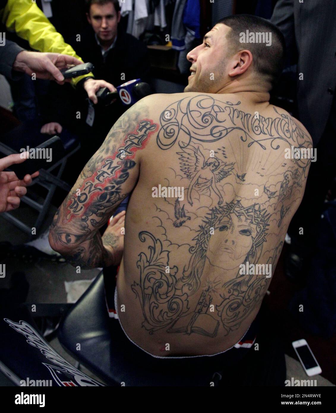 FILE - In this Jan. 27, 2012, file photo, then-New England Patriots tight end Aaron Hernandez talks to reporters at his locker after NFL football practice in Foxborough, Mass. Investigators asked for help from tattoo artists who may have inked Hernandez, saying they could help in the prosecution of a double murder Hernandez is charged with committing in 2012. The Suffolk district attorney's office stressed that the tattoo artists are considered witnesses, not suspects, and "may have made observations of evidentiary value." AP Photo/Elise Amendola, File) Stock Photo