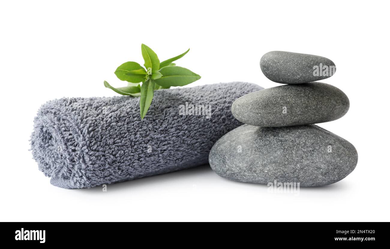 Spa stones, green leaves and towel on white background Stock Photo