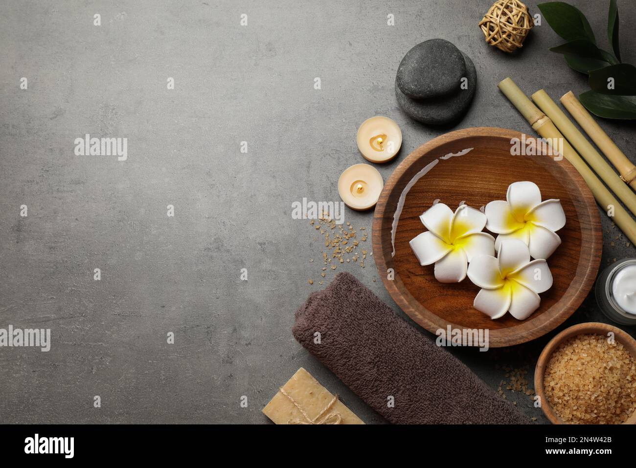 Flat lay composition with spa stones on grey table, space for text ...