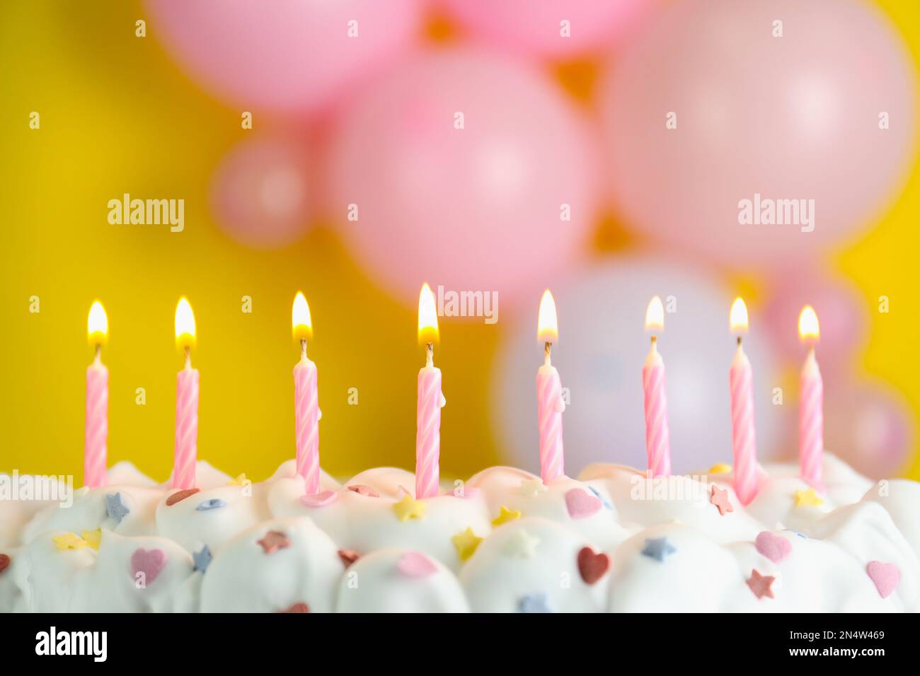Birthday cake with burning candles on blurred background, closeup Stock ...