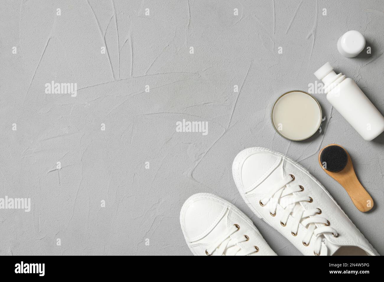 Applying a water-repellent hydrophobic spray to white women's sneakers.  Protection of shoes from moisture, dirt and unpleasant odor Stock Photo -  Alamy